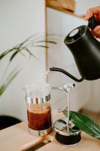 pouring water on french press with coffee